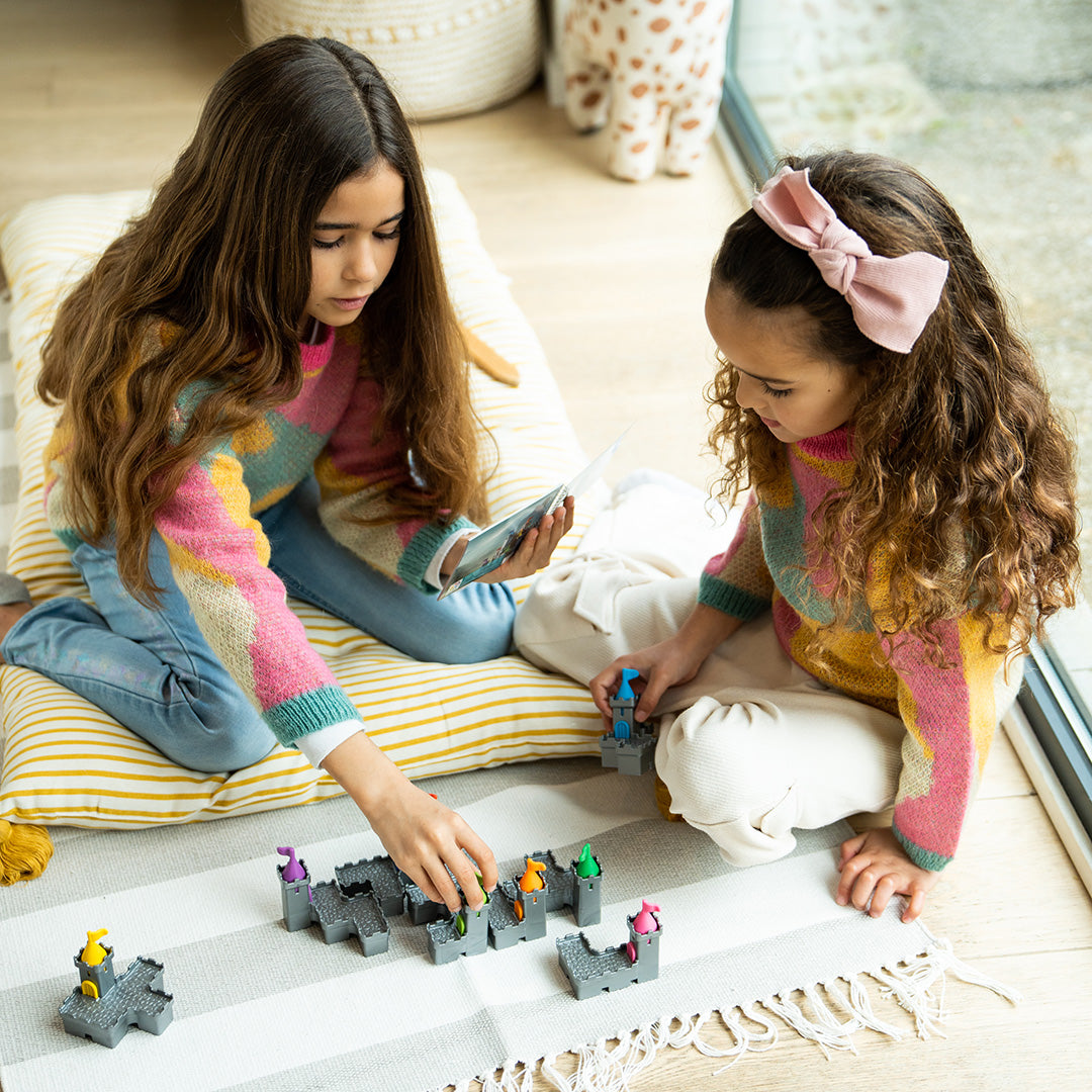 Photo of two girls sitting on the floor playing the Tower Stacks mind puzzle by Smart Games.